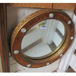 A circular gilt mirror with velvet and glass decoration and a triple dressing table mirror
