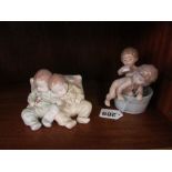 A Lladro group two babies sleeping and another two children in a bath