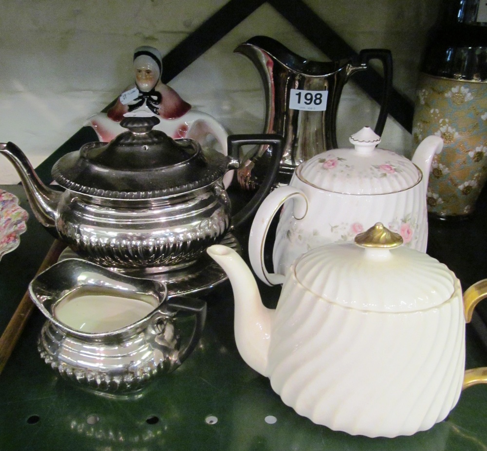 A silver lustre teapot on stand and two jugs and three other teapots