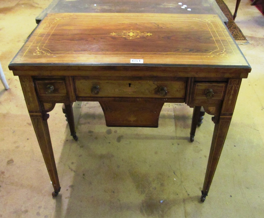 A late Victorian rosewood games/work table with a foldover top revealing backgammon, chess and