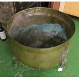 A large brass log bin with lion ring handle and paw feet