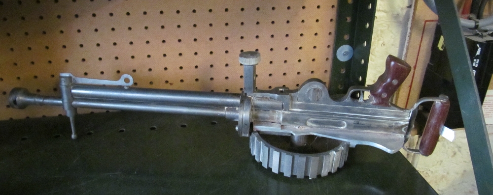 A metal gun sight mounted on base and another gun style instrument