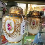 A pair of Noritake vases decorated reserves of roses within gilt embellishments (both lids