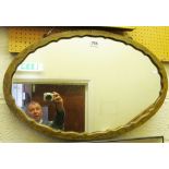 An oval mirror in painted frame