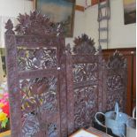 A carved Burmese style three fold screen of floral design