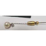 A 14k white gold stick pin set pearl and diamond