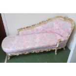 An ornate white and gilt floral chaise longue