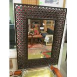A mirror with pierced metal and red bead frame