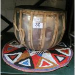 An African drum and a beaded circular hanging