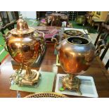 A copper samovar with horned mask handles, another samovar (no lid) and a copper tray