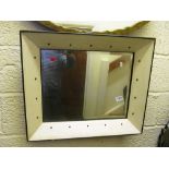 A mirror with cream and studded frame