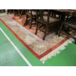 A Chinese carpet orange and cream ground with vase and flower motifs