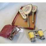 A pair of pseudo ivory clad opera glasses and an embroidered dressing table set