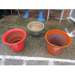 A red and an orange garden pot and a green pot