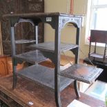 A 1920s oak multi tier occasional table with two drop down side shelves and carved edges