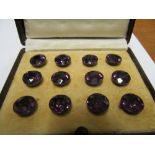 A set of twelve purple stone studs in leather case
