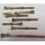 Seven gold coloured extending pencils three inset turquoise