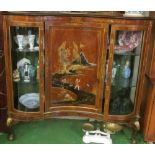 A walnut and lacquer serpentine fronted display cabinet the central panel depicting a path to temple