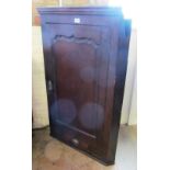 An early 19th Century oak corner cabinet with panelled door