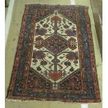 A Persian design rug cream ground with central stepped gul within blue and pink borders