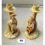 A pair of Edwardian Worcester cream ware candlesticks with boy and girl