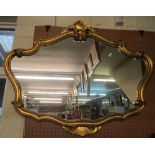 A shaped gilt framed mirror