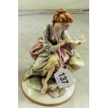 A Capodimonte figure lady seated with bird