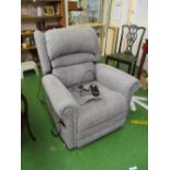 An electric recliner chair upholstered in grey
