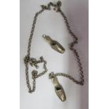 A pair white metal miniature shoes on guard chain