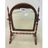 A small arched top toilet mirror with turned supports