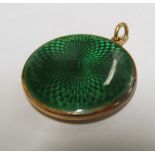 A circular photo locket engine turned back and green enamel front