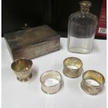 A glass flask with silver lid, silver cigarette box, silver egg cup and three silver napkin rings