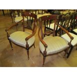 A pair of Empire style mahogany elbow chairs on turned legs