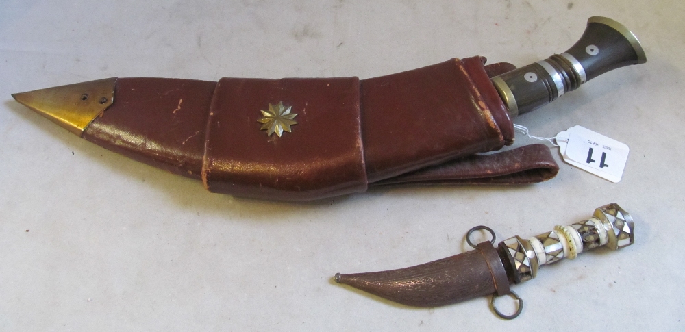 A dagger in a leather holster signed military with two small daggers and a small mother of pearl