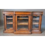 A Victorian Rosewood Breakfront Side Cabinet with three carved and glazed doors raised upon a