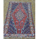 A North West Persian Woollen Rug with a central medallion within an allover design upon a