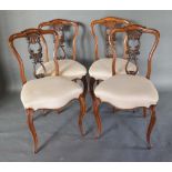 A Set of Four Victorian Walnut Balloon Back Chairs, each with a carved pierced shaped back and