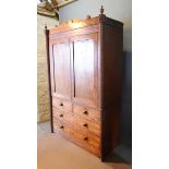 A Regency Mahogany Linen Press with a shaped cornice and two turned finials above a pair of panelled