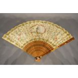 A 19th Century fan, hand painted with reserves within gilded decoration with finely pierced sticks
