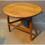 A George III Oak Cricket Table, the circular top above a shaped frieze raised upon three supports