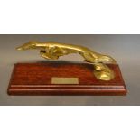 A Brass Car Mascot in the form of a greyhound, 18cm long, a pair of Brass Models in the Form of