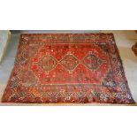 A North West Persian Woollen Carpet with three central medallions within an allover design upon a