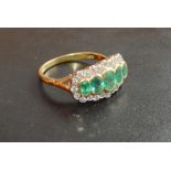 An 18 Carat Gold Emerald and Diamond Ring set with five graduated emeralds surrounded by diamonds