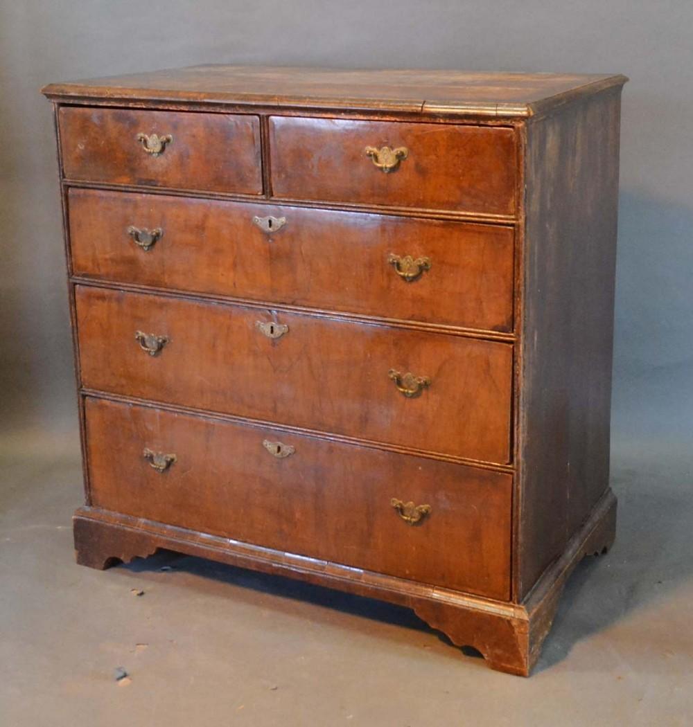 A George II Walnut Chest, the moulded top above two short and three long graduated drawers with