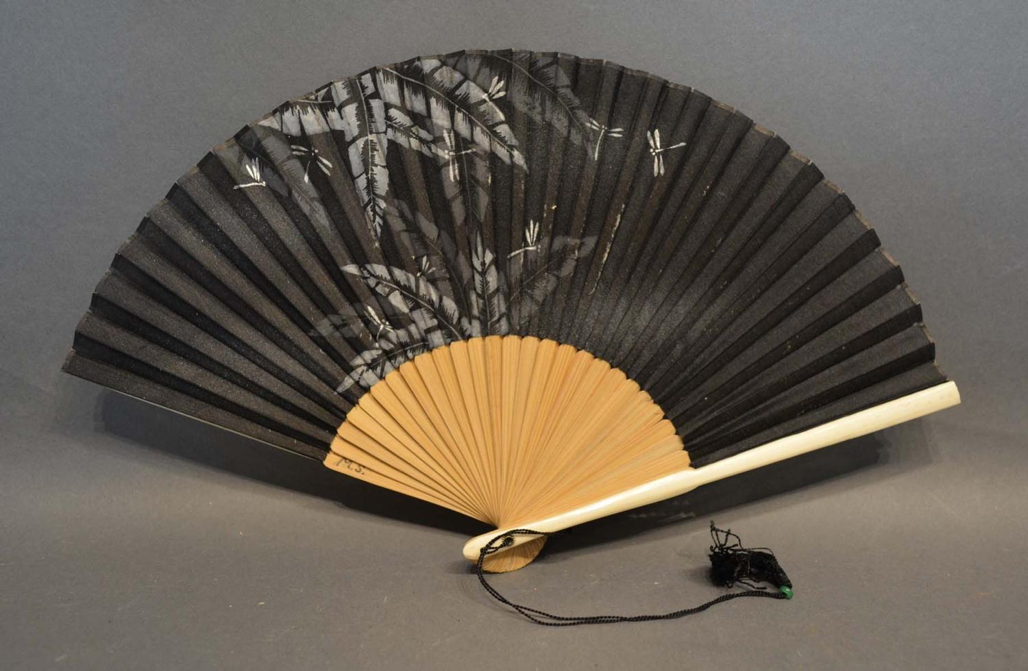 A Black Silk Leafed Fan, hand painted with dragonflies amongst foliage with bamboo sticks and