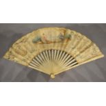 An 18th Century Carved Ivory fan, the skin lithographed and painted with classical figures within