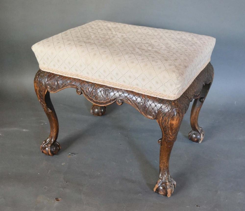 A 19th Century Rectangular Stool with an upholstered seat above a carved frieze raised upon cabriole
