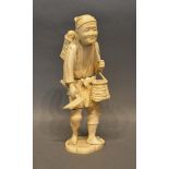 A Japanese Meiji Carved Ivory Model in the form of a tradesman, 22.5cm tall