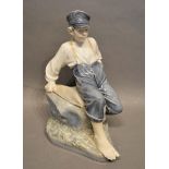 A Royal Copenhagen Porcelain Large Model of a Fisherboy Seated on a Rock, numbered 1659, 30cm tall