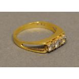 An 18 Carat Yellow Gold Three Stone Diamond Ring set with three diamonds within an unusual pierced